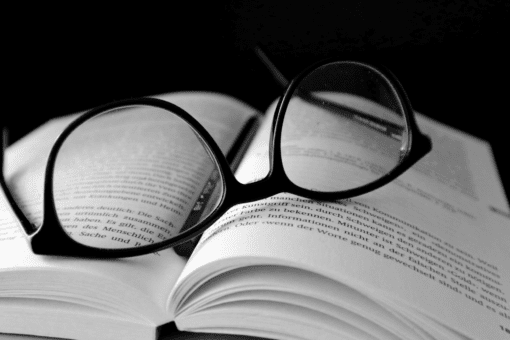Eye glasses rest atop a book.