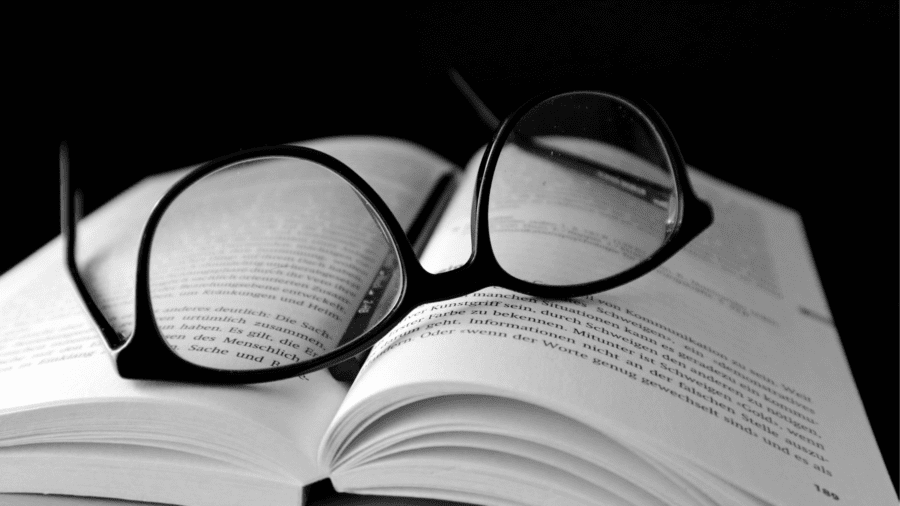 Eye glasses rest atop a book.